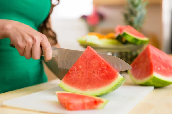 Close up of watermelon slice in kitchen hand knife seedless organic fresh nutritional snack
