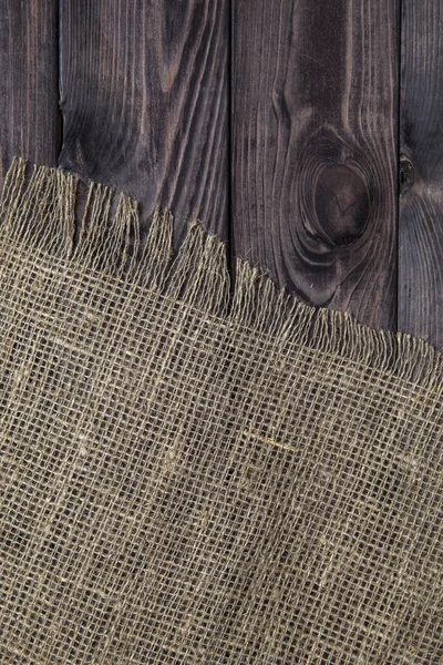 Burlap texture on old wooden table background. Wooden table with sacking
