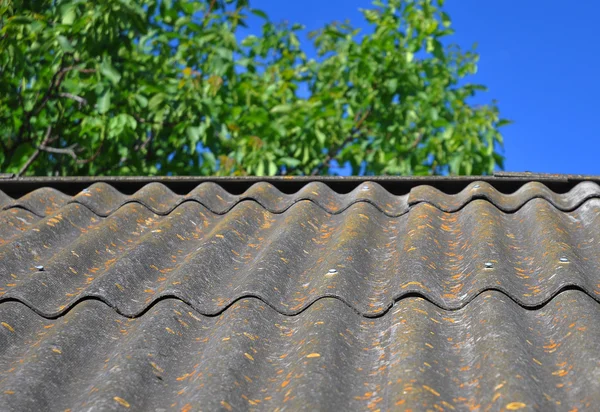 Blue sky over the dangerous asbestos old roof tiles able to use