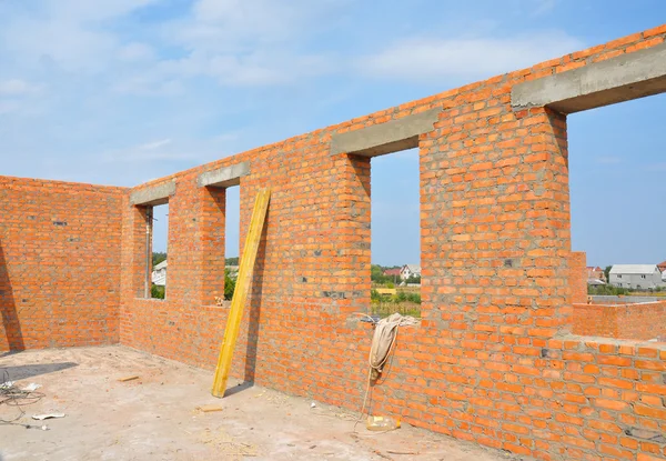 Interior of a unfinished red brick house under construction. Closeup on windows hole construction