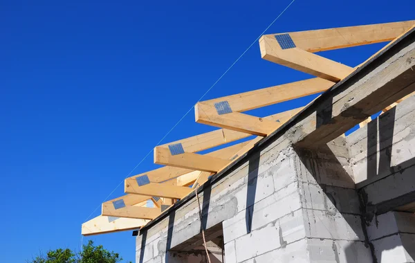 Installation of wooden beams at construction the roof truss system of the house. Roofing.