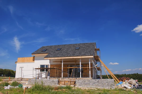 New Cozy House Building Construction Exterior. Cozy house with Dormers, Skylights, Ventilation, Gutter, Drainage, Plastering and Painting.