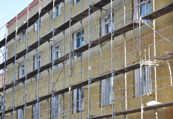 Exterior house wall heat insulation with mineral wool, building under construction.