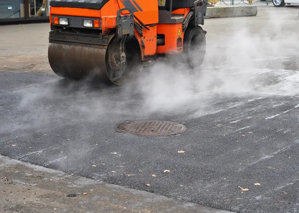 Road repair, compactor lays asphalt. Repair pavement and laying new asphalt patching method outdoors.