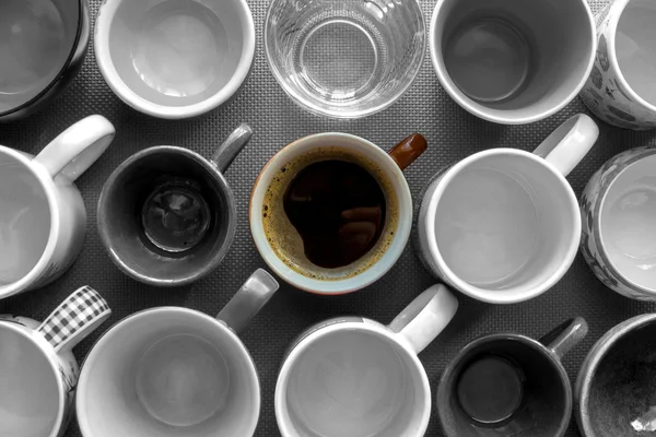 Cup of coffee between the empty cups