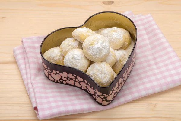 Small cookies in a tin box on cotton checkered napkin