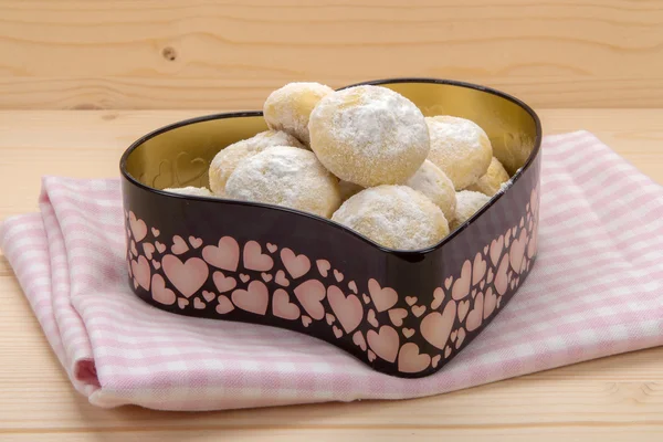Cookies in a tin box in heart shape on cotton checkered napkin