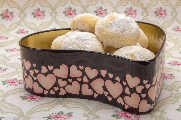 Cookies in powdered sugar in a tin box in heart shape