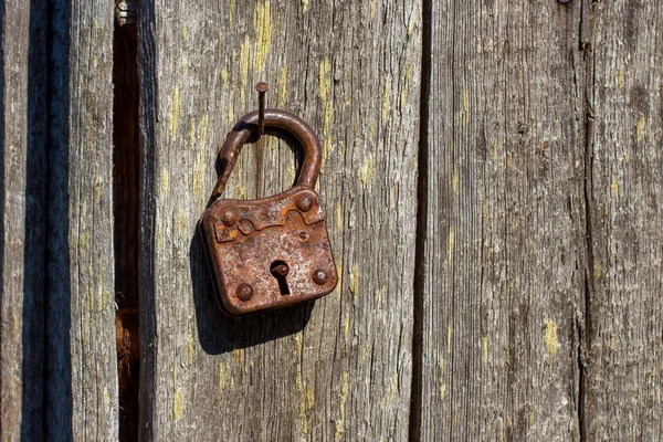 Rusty padlock on a rusty nail