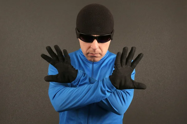 Man in black glasses shows a negative sign with hands