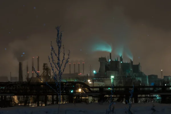 Power station with steam cloud blown by the wind in a cold starry winter night