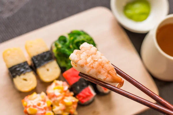 Sushi set with chop sticks, wasabi served on wooden slate, selec