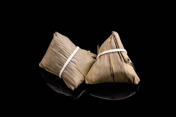 Two Zongzi or Asian Chinese sticky rice dumplings with isolated