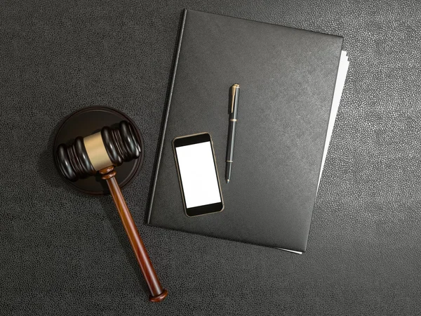 Wooden judges gavel and phone on black leather desk