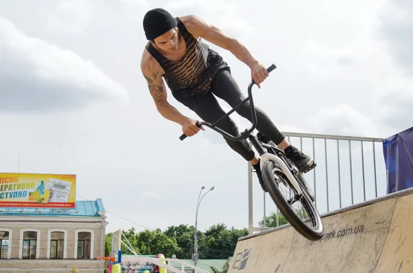 Young boy is showing extreme jumps on a skate stage