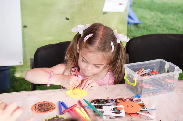 KHARKIV, UKRAINE - JUNE 18, 2016: Day of music held in Kharkiv, Ukraine. Unidentified girl is drawing elementary pictures in the playground for children.