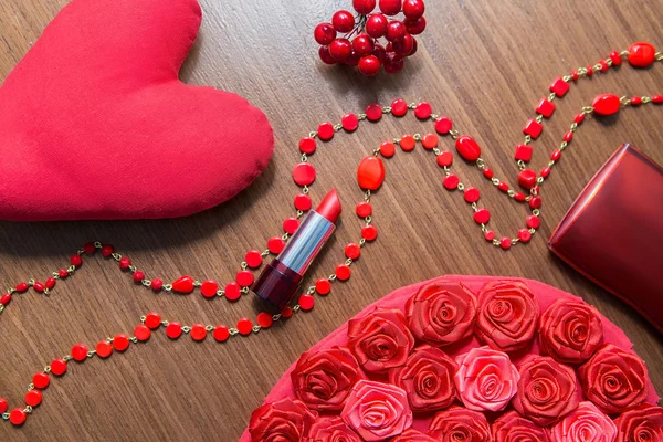 Red lipstick and powder box on a wooden background