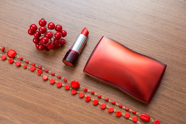Red lipstick and powder box on a wooden background
