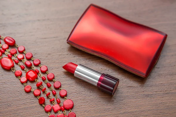 Red lipstick and powder box on the wooden background