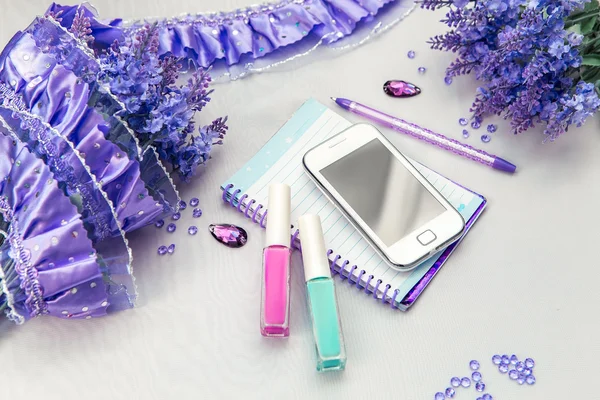 Office supplies business women. Still life. Phone notebook and pen. Some office stuff on a white background. Accessories on the table. Purple color interior details.