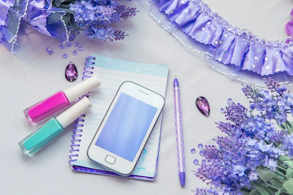 Office supplies business women. Still life. Phone notebook and pen. Some office stuff on a white background. Accessories on the table. Purple color interior details.
