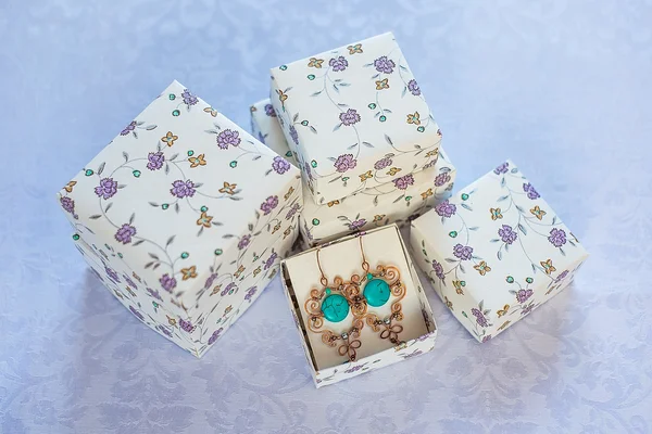 Floral pattern simple boxes for stuff on a white background with handmade turquoise earrings