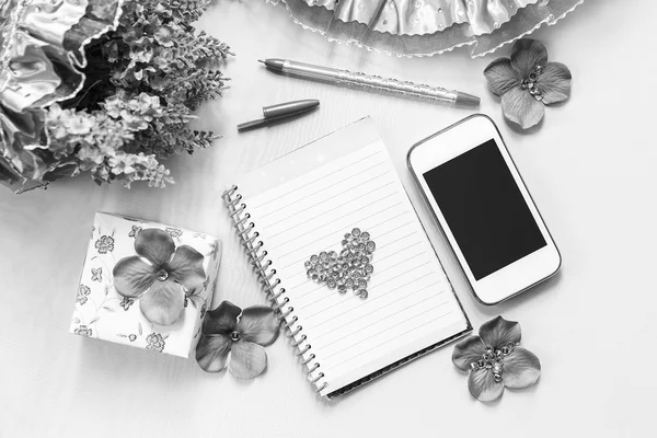 Phone, notebook and pen. Some office stuff on a white background. Accessories on a desk. Black and white color interior details.