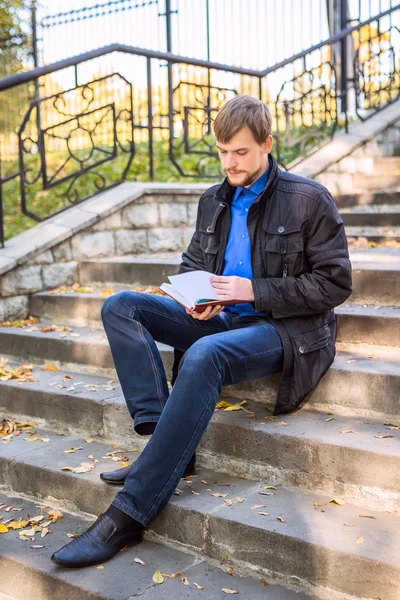 A man sitting with the book in the city park