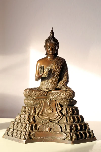 Statue of sitting  in a gesture of blessing Buddha illuminated by the setting sun