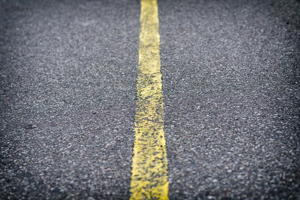 Detail of asphalt road with yellow line