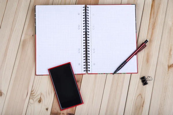Smart Phone And Notepad On Desk