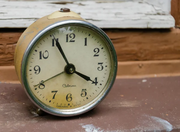 HUNGARY - JULY 30, 2015: retro soviet alarm clock on the painty old window sill