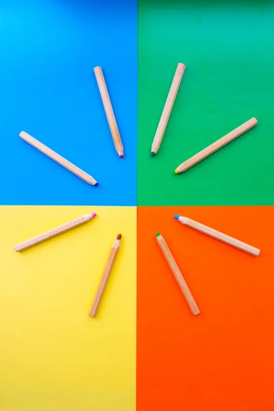 Colorful picture of wooden pencils circled around edges of rainbow colors.