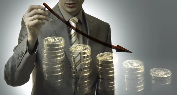 Business concept. businessman drawing a graph down with coins