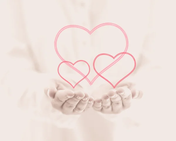 Female hand giving three hearts on pink background