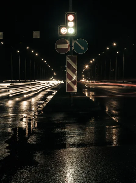 Night traffic in the city and blurry lights from headlights of cars