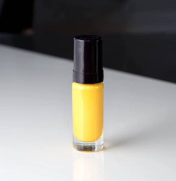 Yellow nail polish bottle on white background