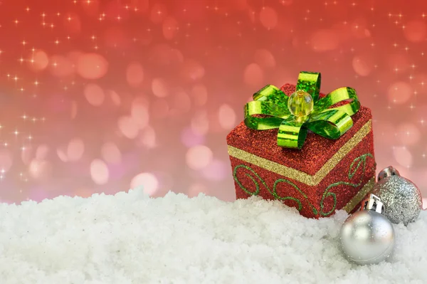 Present box ornament on snow with abstract background