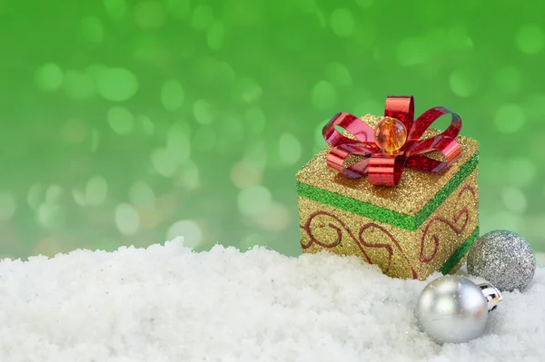 Present box ornament on snow with abstract background