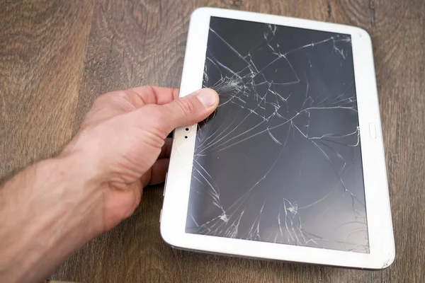 Hand holds tablet PC with broken touchscreen