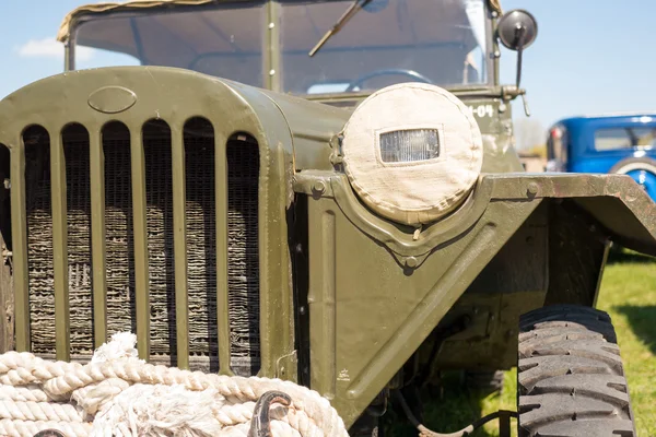 Cabin of old military truck with camouflaged headlight.