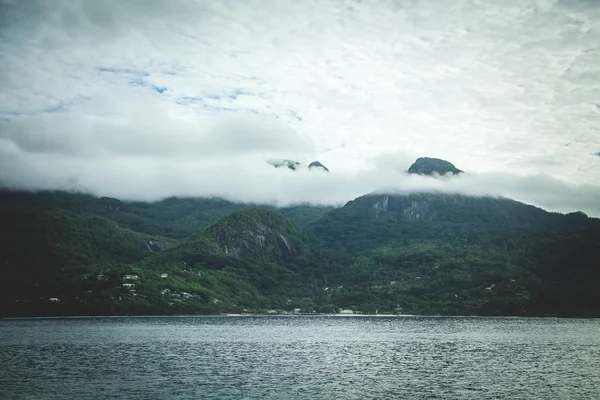 Mountains and ocean under cloudy sky