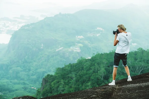Photographer taking photo of mountain landscape