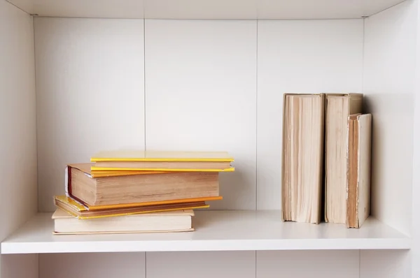 Old books or text books on wooden bookshelf.