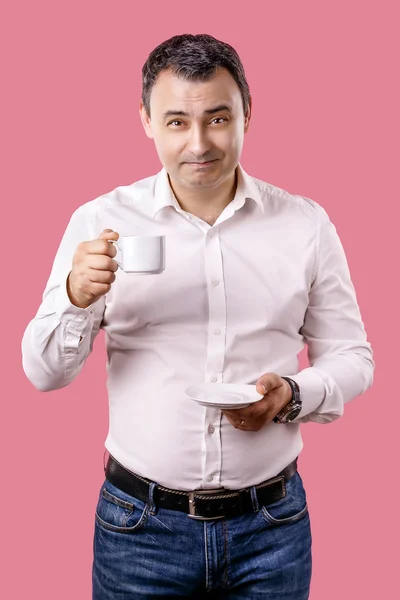 Portrait happy, smiling business man, lawyer drinking cup coffee isolated pink background. Human face expression, emotion, corporate executive.