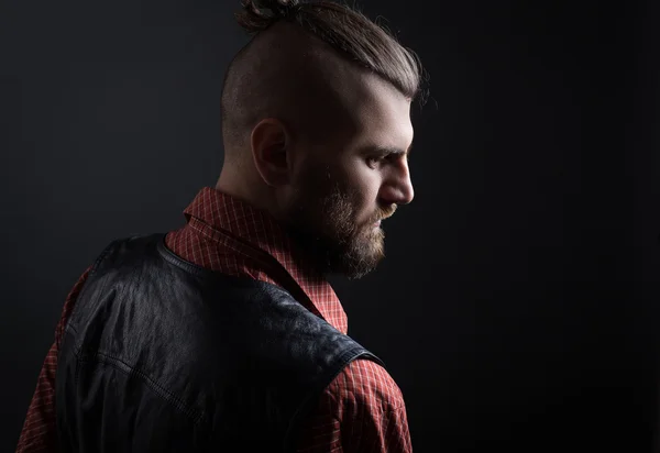 Brutal man with beard and hairstyle looking down