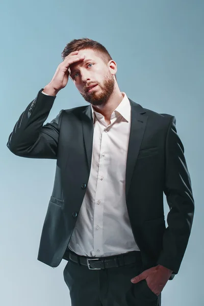 Studio shot of a stylish bearded man in elegant suit, colored tiffany background, isolate thinking, sad, very emotionally