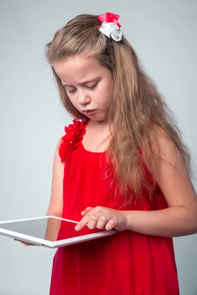 Girl in red dress holding digital tablet.