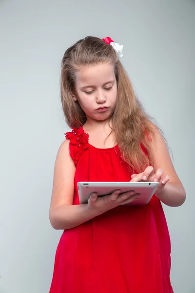 Girl in red dress holding digital tablet.