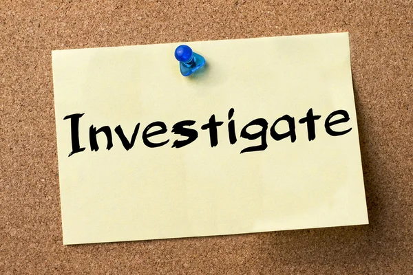 Investigate - adhesive label pinned on bulletin board